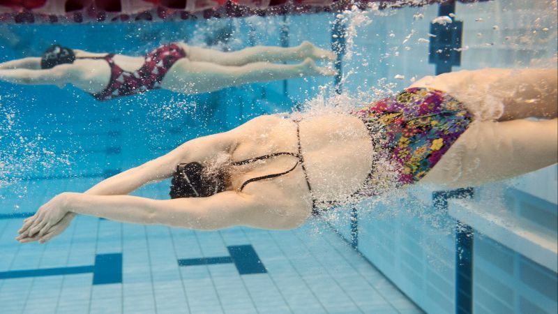 un nadador se empuja desde la pared e inmediatamente gira hacia un lado para sus patadas bajo el agua